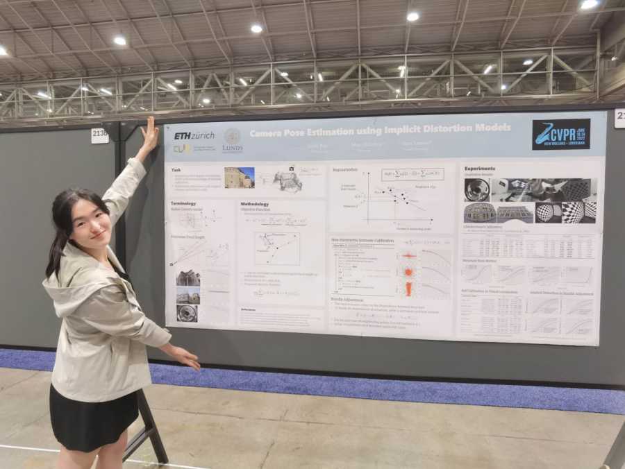 Linfei Pan zeigt ihr wissenschaftliches Poster auf einer Konferenz
