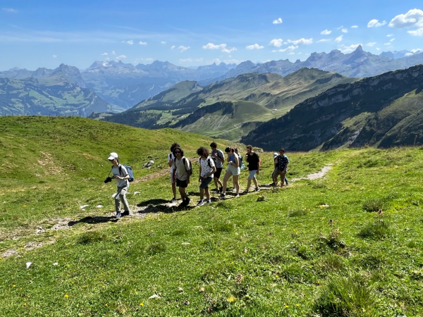 Die Studierenden wandern an einem sonnigen Tag durch die Schweizer Berge.