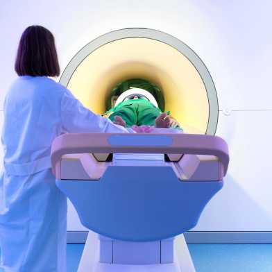 Medical professional pushes patient into MRI machine