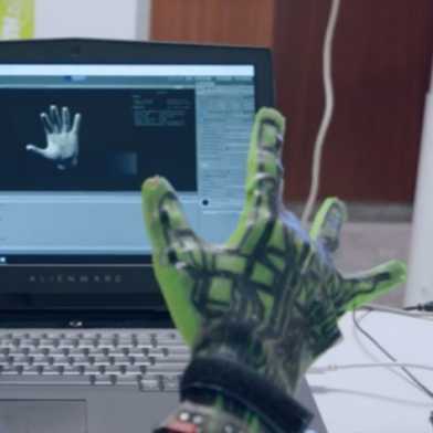 A person uses a data glove with a computer