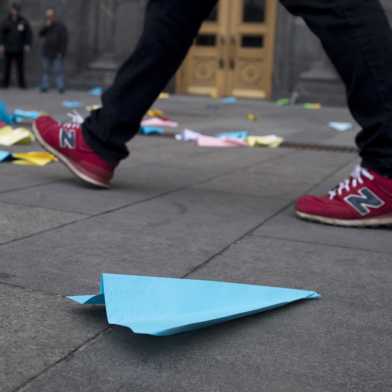 Blue paper plane on ground (photo: Keystone)