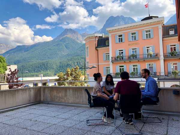 Workshop participants sitting on a terrace with mountain view