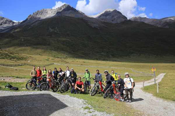 Group photo of participants with mountainbikes in the mountains.