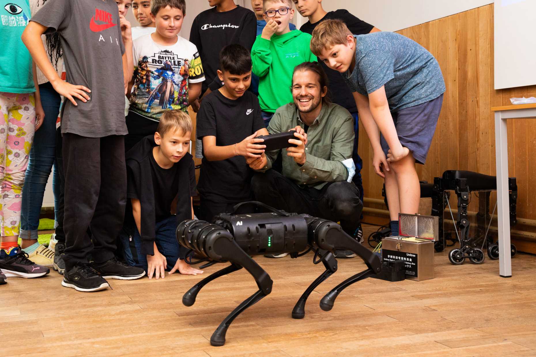Moritz Geilinger shows a four-legged robot to the children in the Pestalozzi School Camp.