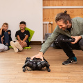 Moritz Geilinger showes a four-legged robot to the children at the Pestalozzi Schulcamp. Photo: Ketty Bertossi