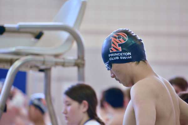 Daniel Yang at the pool wearing a swimming cap with the Princeton logo and the inscription 