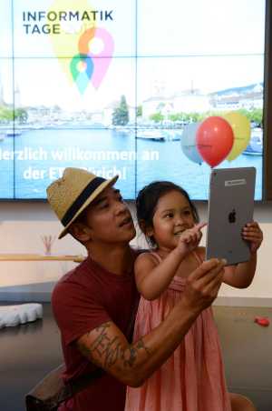 father-daughter taking a picture with tablet