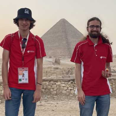 Two students standing in front of a pyramide.