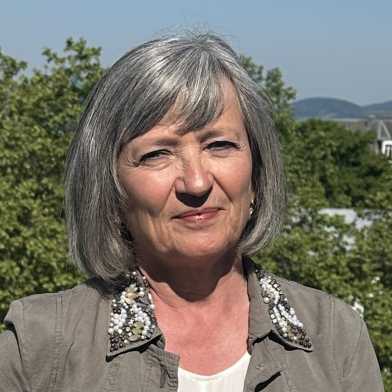 A woman on a balcony, in the background is Zurich.